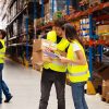Trabajadores gestionando inventario en administración de bodegas logísticas, con control de stock y almacenamiento de productos