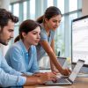 Equipo de profesionales analizando métricas y gráficos de Google Analytics 4 en computadores durante una sesión de trabajo digital.