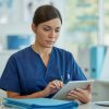 Enfermera revisando documentos administrativos en hospital, gestión de recursos humanos para la salud.