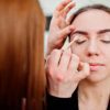 Persona recibiendo una clase de maquillaje, aplicando sombras en los ojos como parte del curso online de visagismo y automaquillaje.