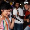 Cantante interpretando canto popular con técnica vocal en presentación musical junto a músicos en vivo