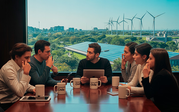 Grupo diverso de profesionales chilenos en oficina moderna, colaborando en proyectos de sostenibilidad, ética empresarial y responsabilidad social corporativa.
