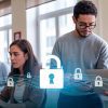 Personas chilenas trabajando en una oficina moderna con laptops, al fondo, y símbolos de ciberseguridad como candados y redes digitales en primer plano.