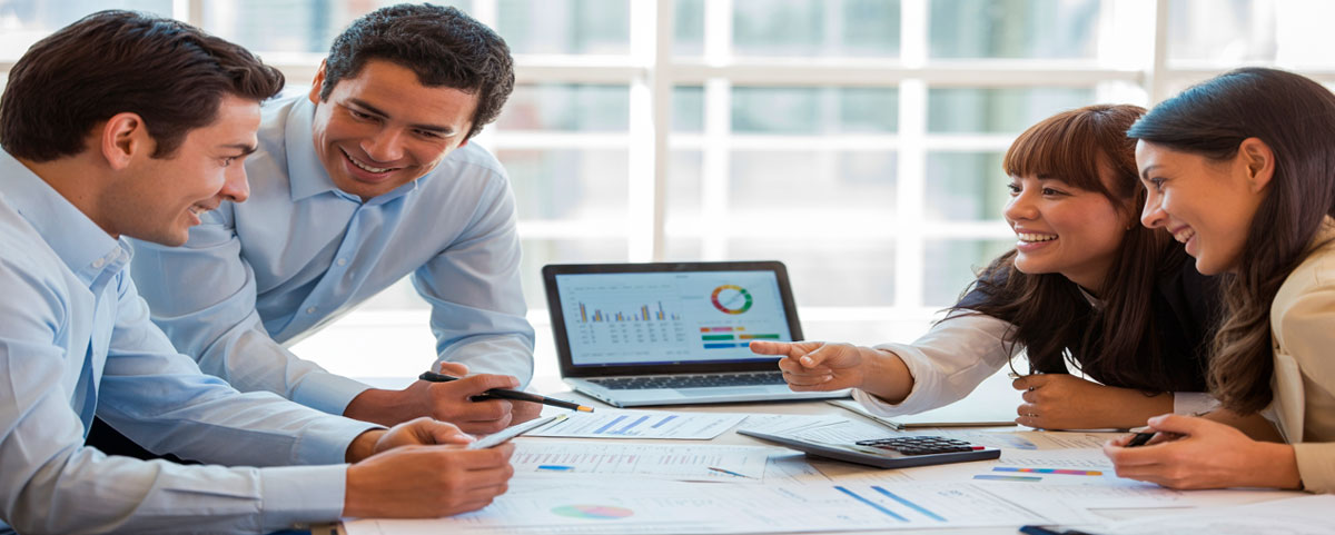 Profesionales trabajando en computador portátil con gráficos financieros, representando la preparación de proyectos y el análisis financiero de inversiones.